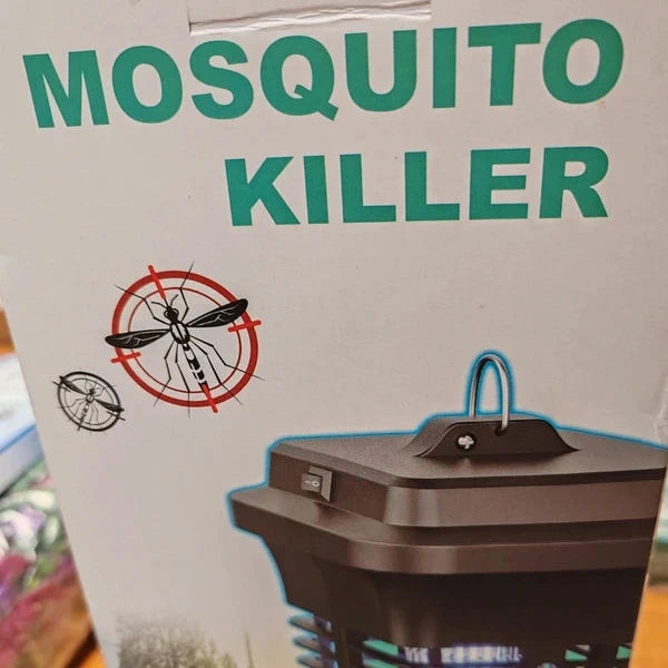 A boxed mosquito killer product shown on a tabletop, with large green text reading 'MOSQUITO KILLER' on the package and a printed photo of the dark insect trap device on the front.