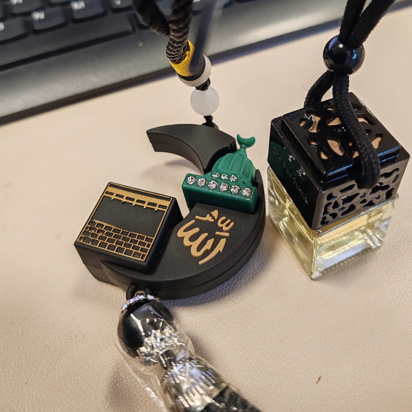 Two decorative necklaces on a desk with a keyboard in the background